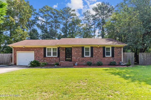 single story home featuring a garage and a front lawn