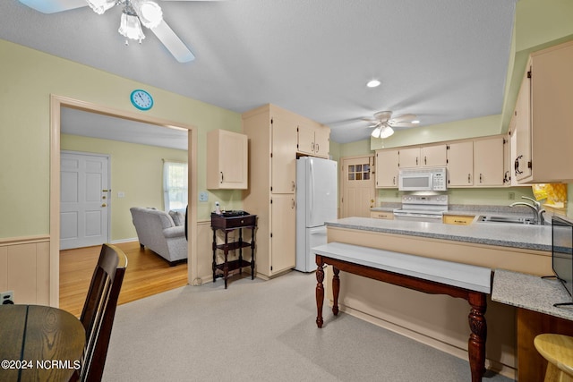 kitchen featuring white appliances, light hardwood / wood-style flooring, sink, cream cabinetry, and ceiling fan