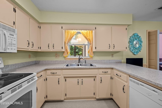 kitchen with white appliances, sink, and cream cabinetry