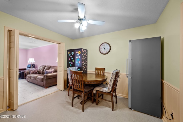 dining room with ceiling fan and light carpet