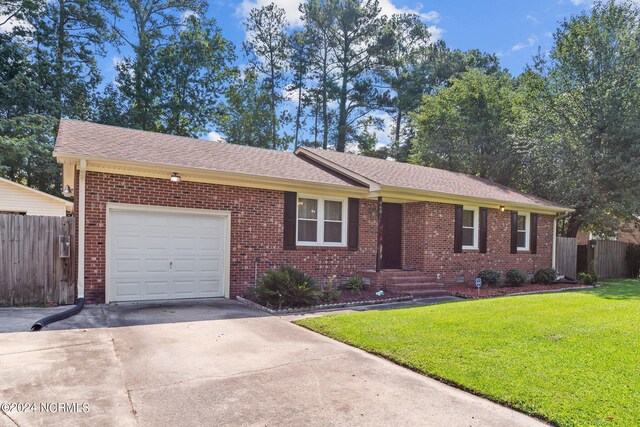 ranch-style home featuring a garage and a front yard