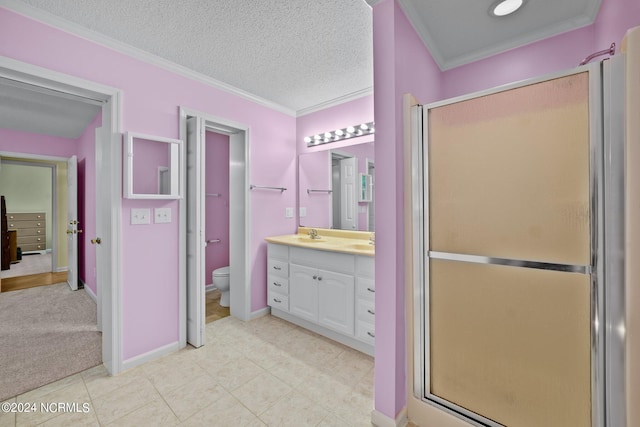 bathroom with crown molding, vanity, toilet, a shower with shower door, and a textured ceiling