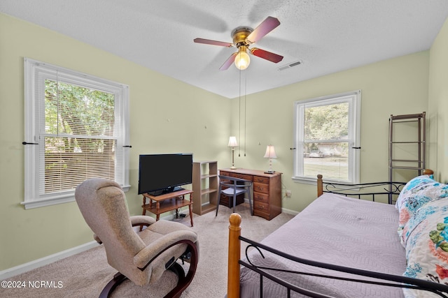 carpeted bedroom with a textured ceiling and ceiling fan