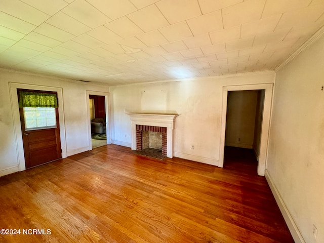 unfurnished living room with dark hardwood / wood-style floors and a brick fireplace