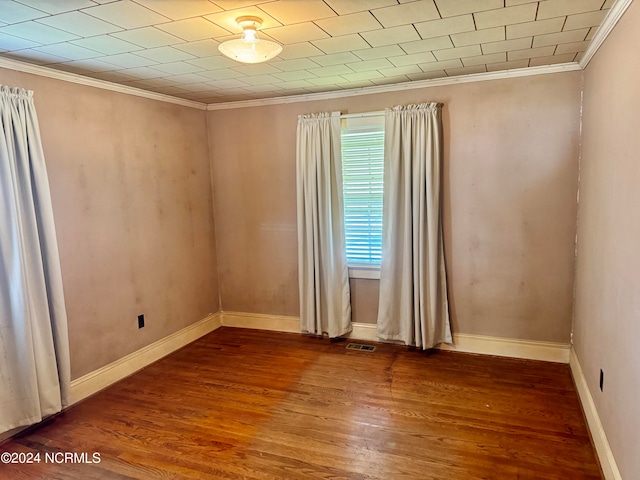 empty room with dark wood-type flooring and ornamental molding