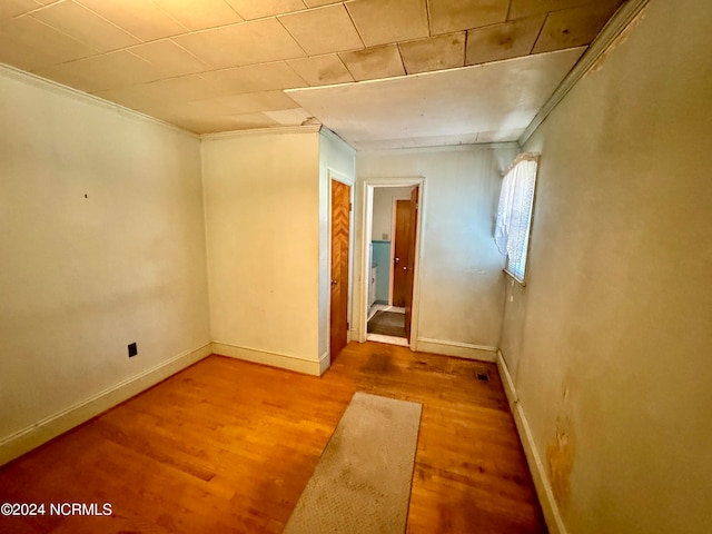 empty room featuring crown molding and light hardwood / wood-style flooring