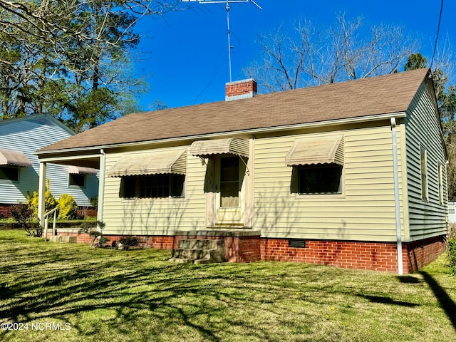 back of property featuring a yard