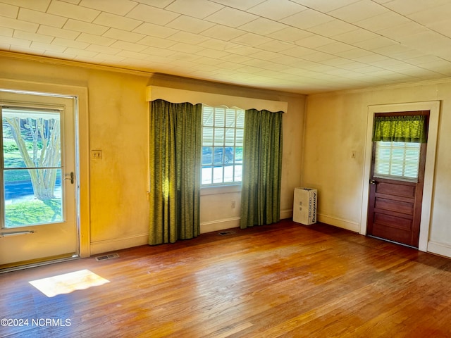 unfurnished room with crown molding and wood-type flooring