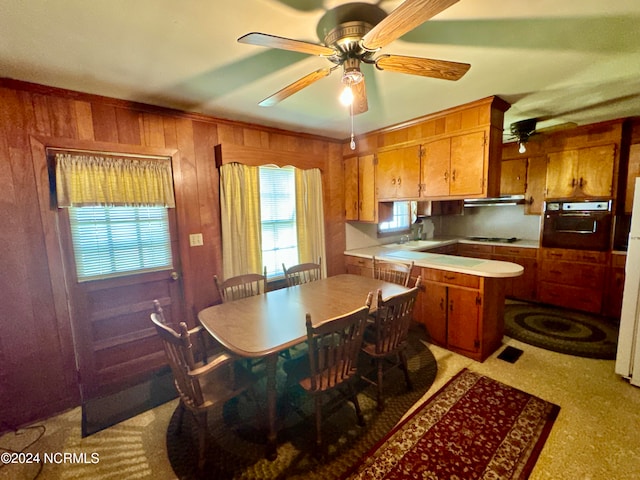 kitchen featuring ceiling fan, stovetop, sink, and oven