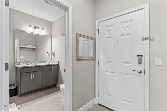 bathroom featuring tile floors, toilet, and vanity with extensive cabinet space