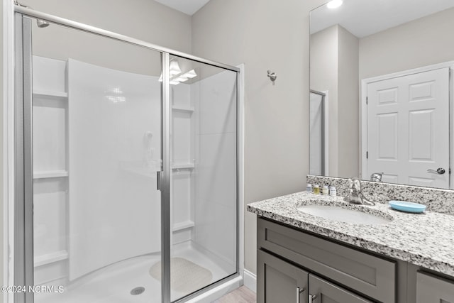 bathroom featuring walk in shower and oversized vanity