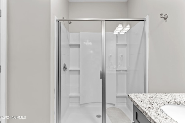 bathroom featuring vanity, a shower with shower door, and tile floors