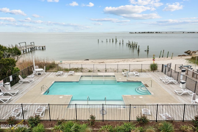 view of swimming pool with a patio and a water view