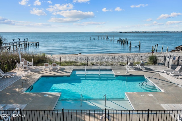 view of swimming pool featuring a patio and a water view