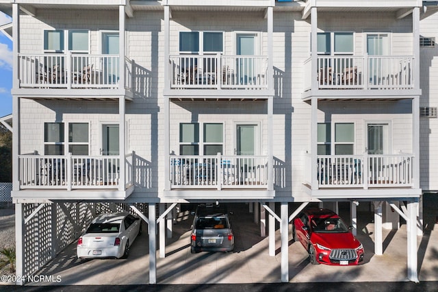 rear view of property with a balcony and a carport