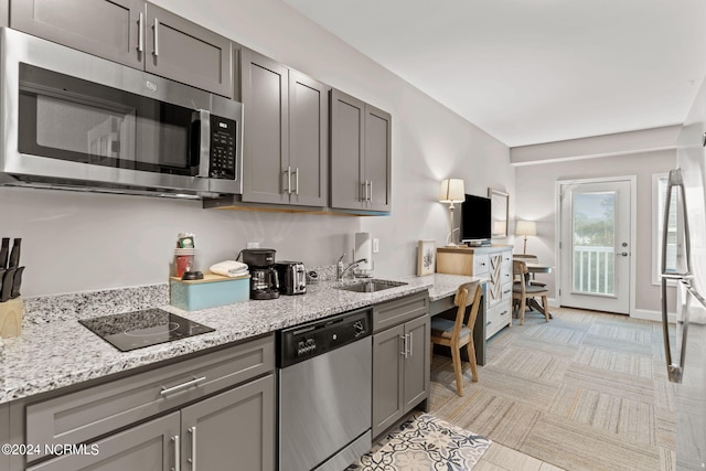 kitchen featuring sink, gray cabinets, light stone counters, and stainless steel appliances