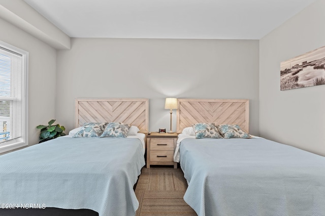 bedroom with dark colored carpet and multiple windows