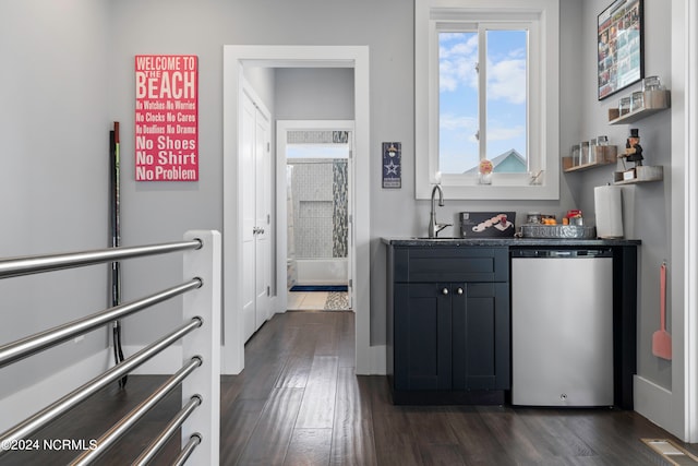 interior space featuring dark hardwood / wood-style floors, sink, and stainless steel dishwasher