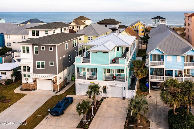 view of front of house featuring a balcony, a garage, and a water view