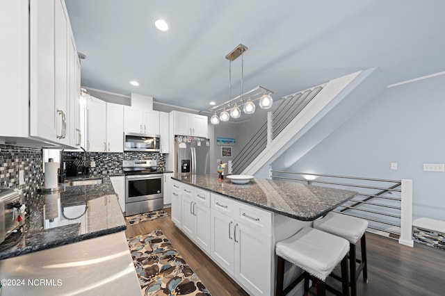 kitchen with appliances with stainless steel finishes, tasteful backsplash, and dark wood-type flooring