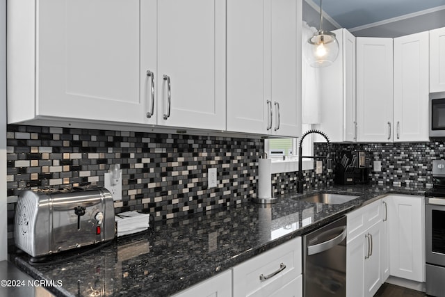 kitchen featuring tasteful backsplash, stainless steel appliances, white cabinets, and decorative light fixtures