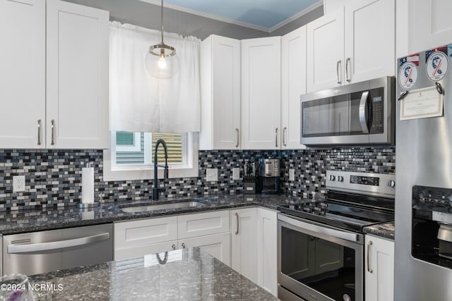 kitchen with decorative light fixtures, appliances with stainless steel finishes, tasteful backsplash, white cabinets, and sink