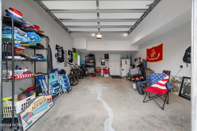 garage with white fridge and a garage door opener