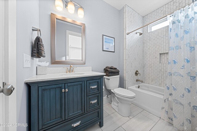 full bathroom featuring toilet, tile floors, large vanity, and shower / bath combo with shower curtain