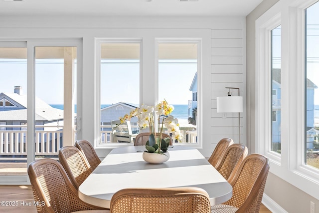 dining space featuring wood-type flooring and a water view