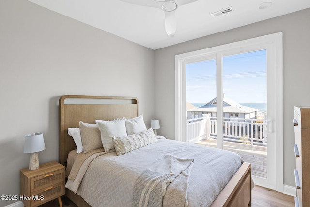 bedroom with access to exterior, multiple windows, and light wood-type flooring