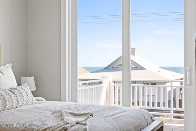 bedroom featuring a water view and multiple windows