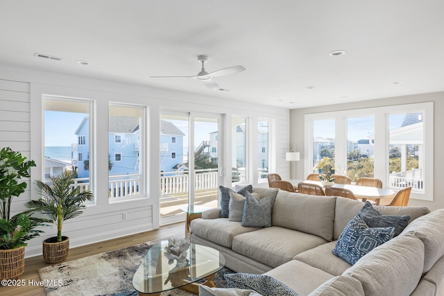 living room with ceiling fan, plenty of natural light, and hardwood / wood-style floors