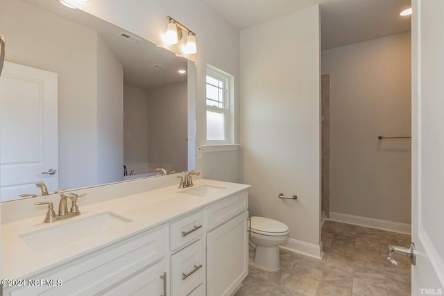 bathroom featuring toilet, double vanity, and baseboards