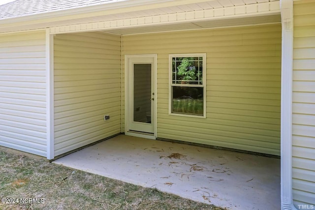 view of exterior entry with a patio area