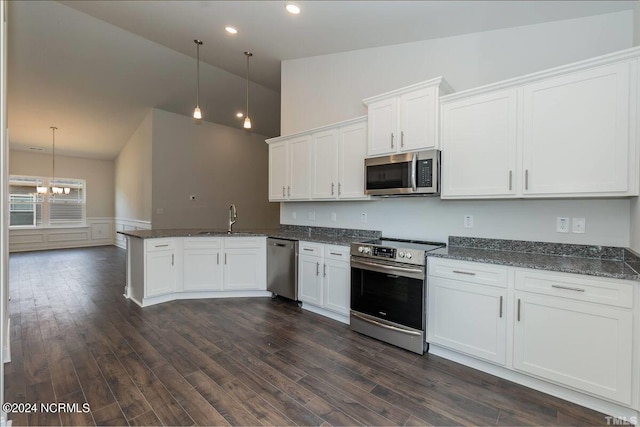 kitchen with appliances with stainless steel finishes, a sink, high vaulted ceiling, a peninsula, and white cabinets