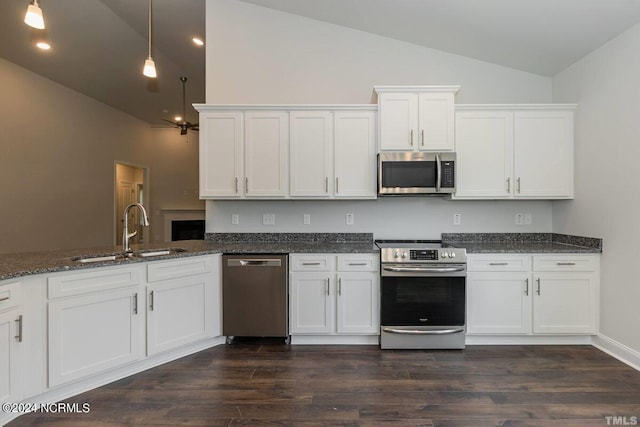 kitchen featuring appliances with stainless steel finishes, a sink, lofted ceiling, white cabinets, and dark wood finished floors
