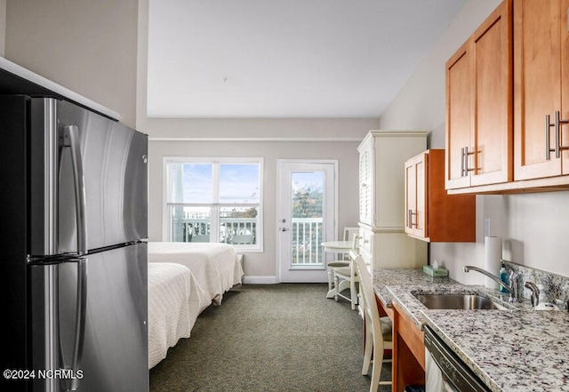 carpeted bedroom featuring access to exterior, stainless steel refrigerator, and sink