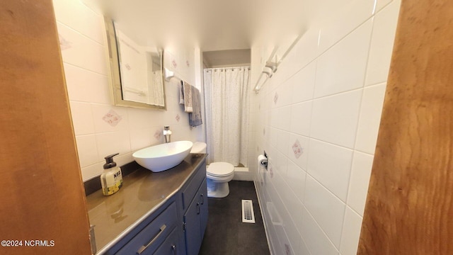 bathroom with tile walls, toilet, and vanity