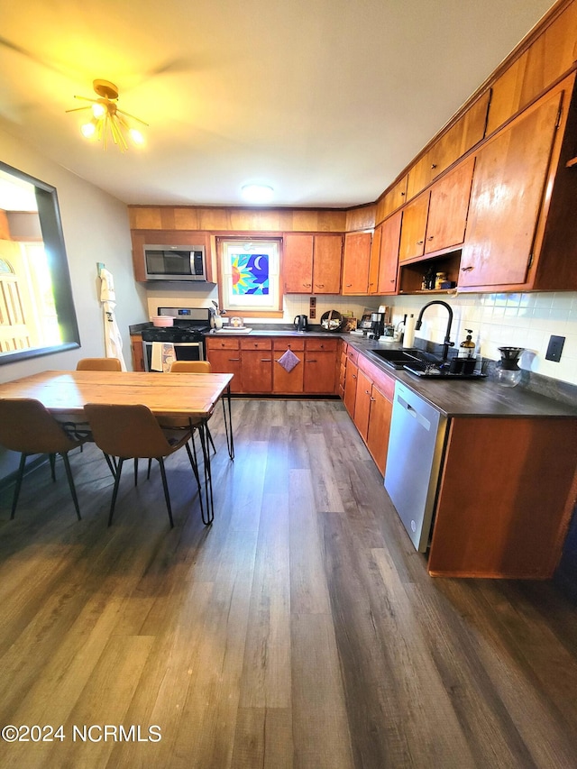 kitchen with ceiling fan, appliances with stainless steel finishes, backsplash, dark hardwood / wood-style floors, and sink