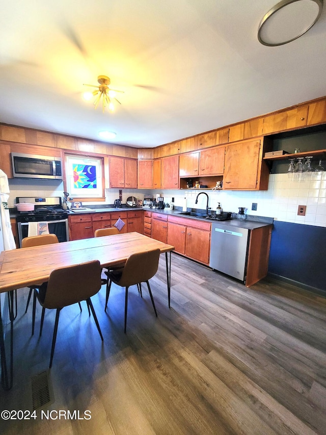 kitchen featuring dark hardwood / wood-style flooring, appliances with stainless steel finishes, ceiling fan, and sink