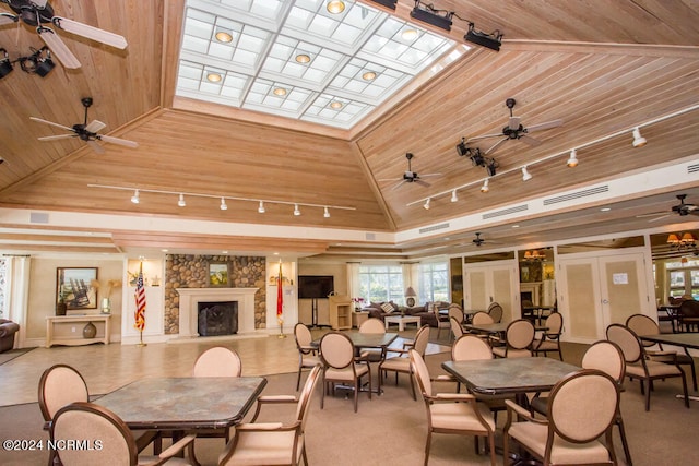 dining area with wood ceiling, ceiling fan, and a fireplace