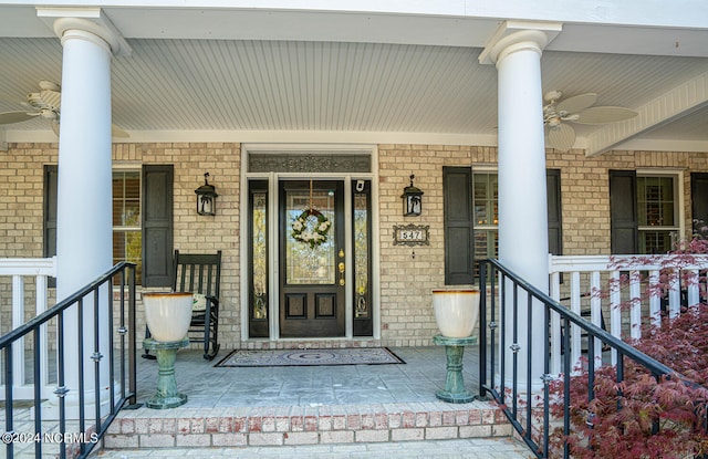 view of exterior entry with a porch and ceiling fan