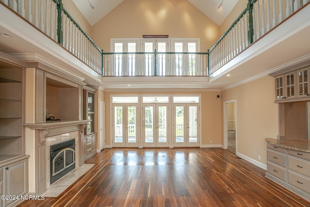 unfurnished living room featuring high vaulted ceiling, dark wood-type flooring, and a fireplace