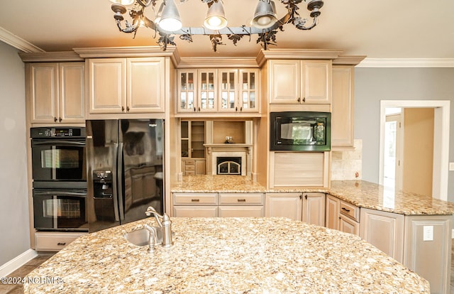 kitchen with sink, black appliances, a notable chandelier, light stone countertops, and crown molding