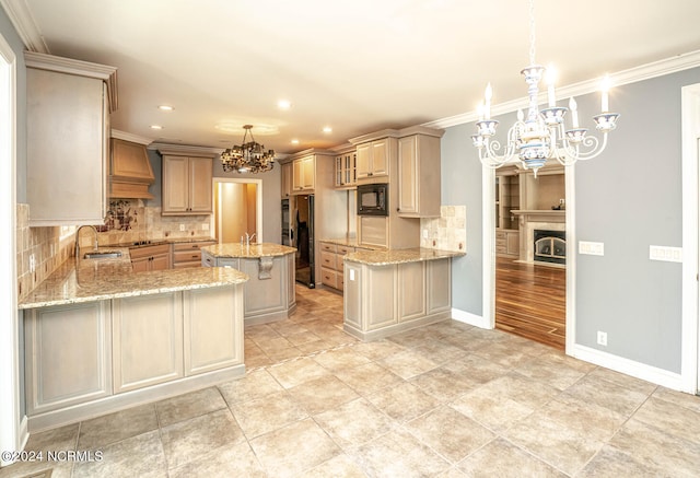 kitchen featuring hanging light fixtures, kitchen peninsula, a kitchen island, black appliances, and a chandelier