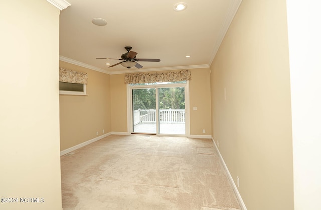 spare room featuring ornamental molding, ceiling fan, and light carpet