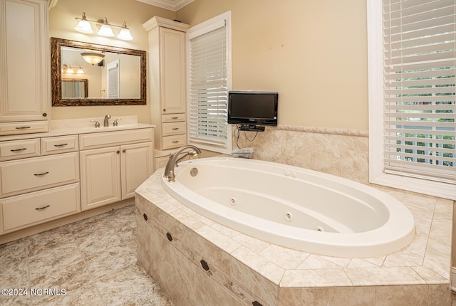 bathroom with ornamental molding, tiled tub, and vanity