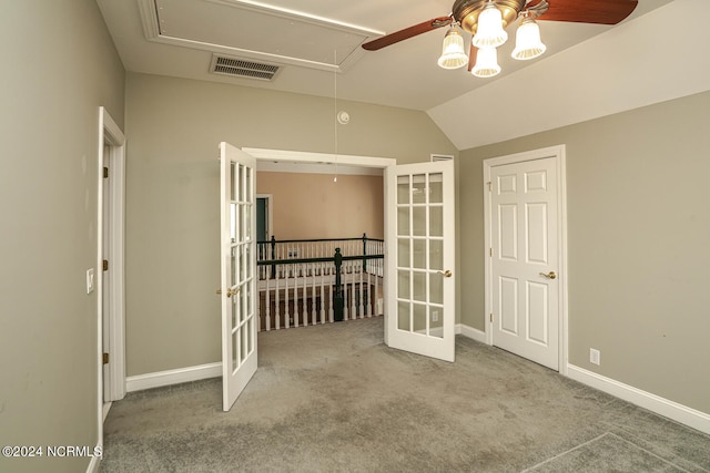 carpeted empty room with lofted ceiling, ceiling fan, and french doors