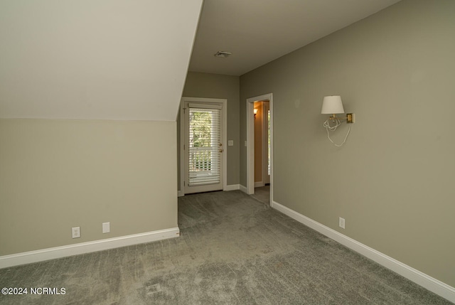 bonus room with vaulted ceiling and carpet flooring