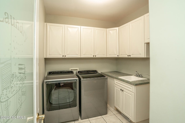 laundry room with washer and clothes dryer, cabinets, light tile patterned flooring, and sink